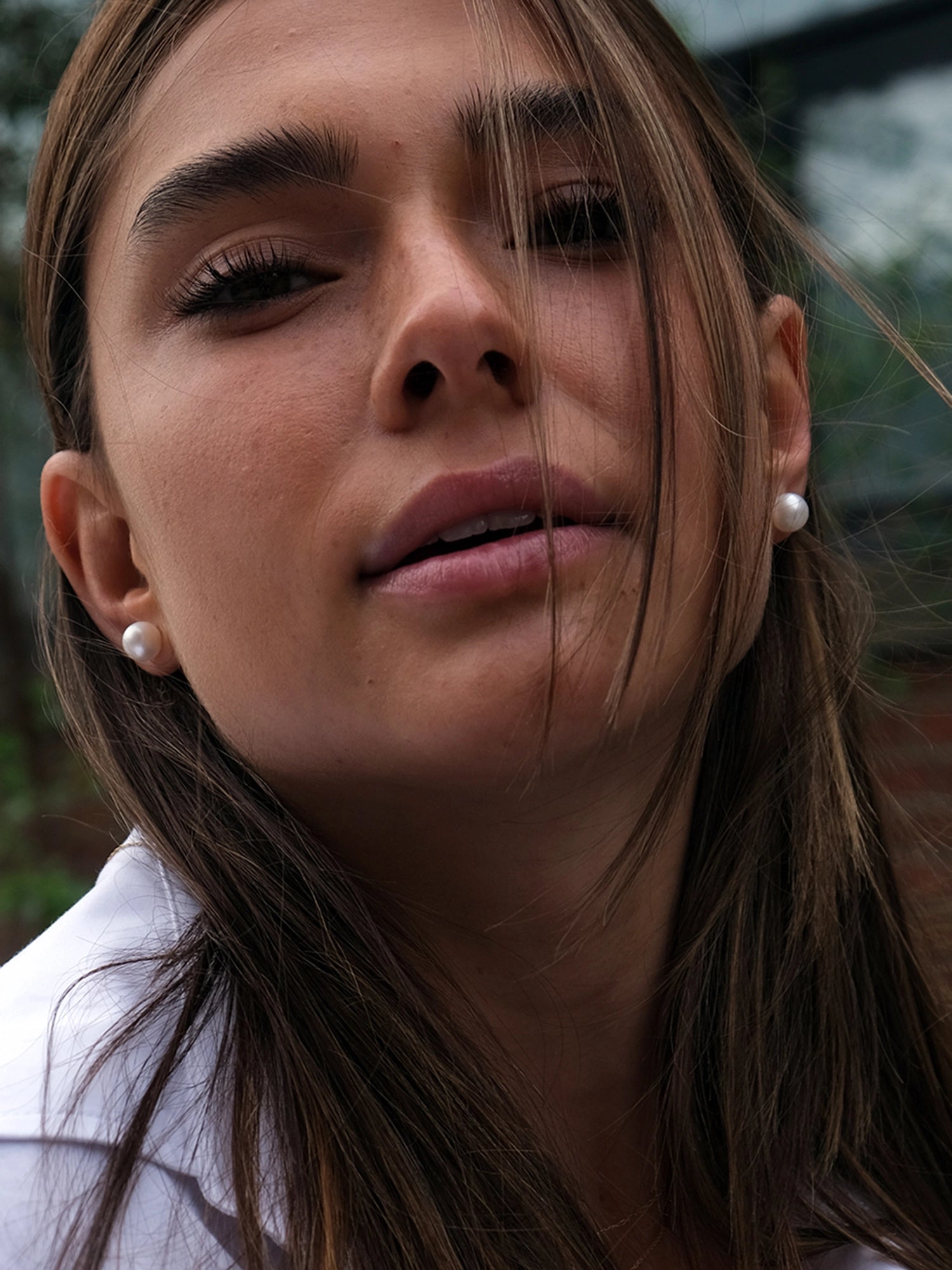 14kt Gold Maxi Studs - 8-9mm white round freshwater pearl earrings in 14kt yellow gold by Nishi Pearls, worn on a model