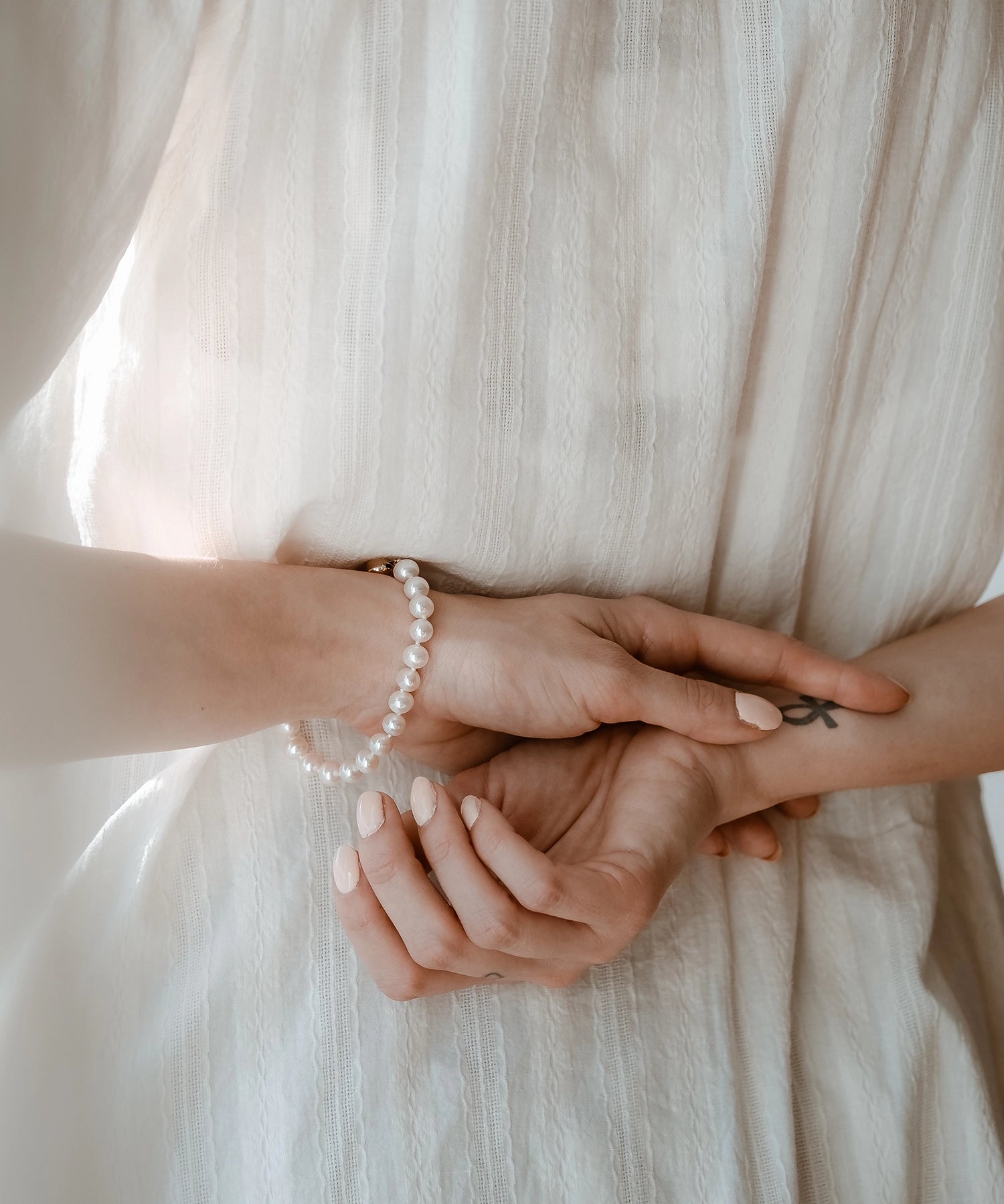 14kt Gold Midi Bracelet - 7-8mm white freshwater pearl bracelet in 14kt yellow gold, 7.25in, by Nishi Pearls, worn on a model