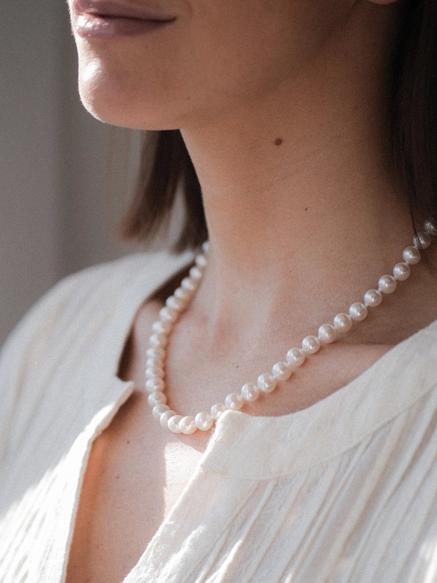 14kt Gold Midi Necklace - 7-8mm white freshwater pearl necklace in 14kt yellow gold, 18in, by Nishi Pearls, styled on a model