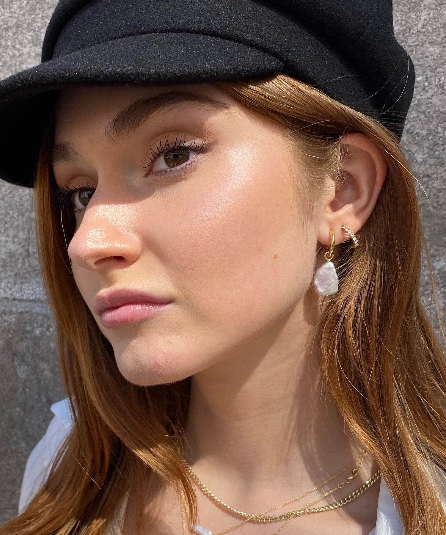 Azalea Hoops - mixed-size white baroque freshwater pearl earrings in yellow gold vermeil by Nishi Pearls, worn on a model

