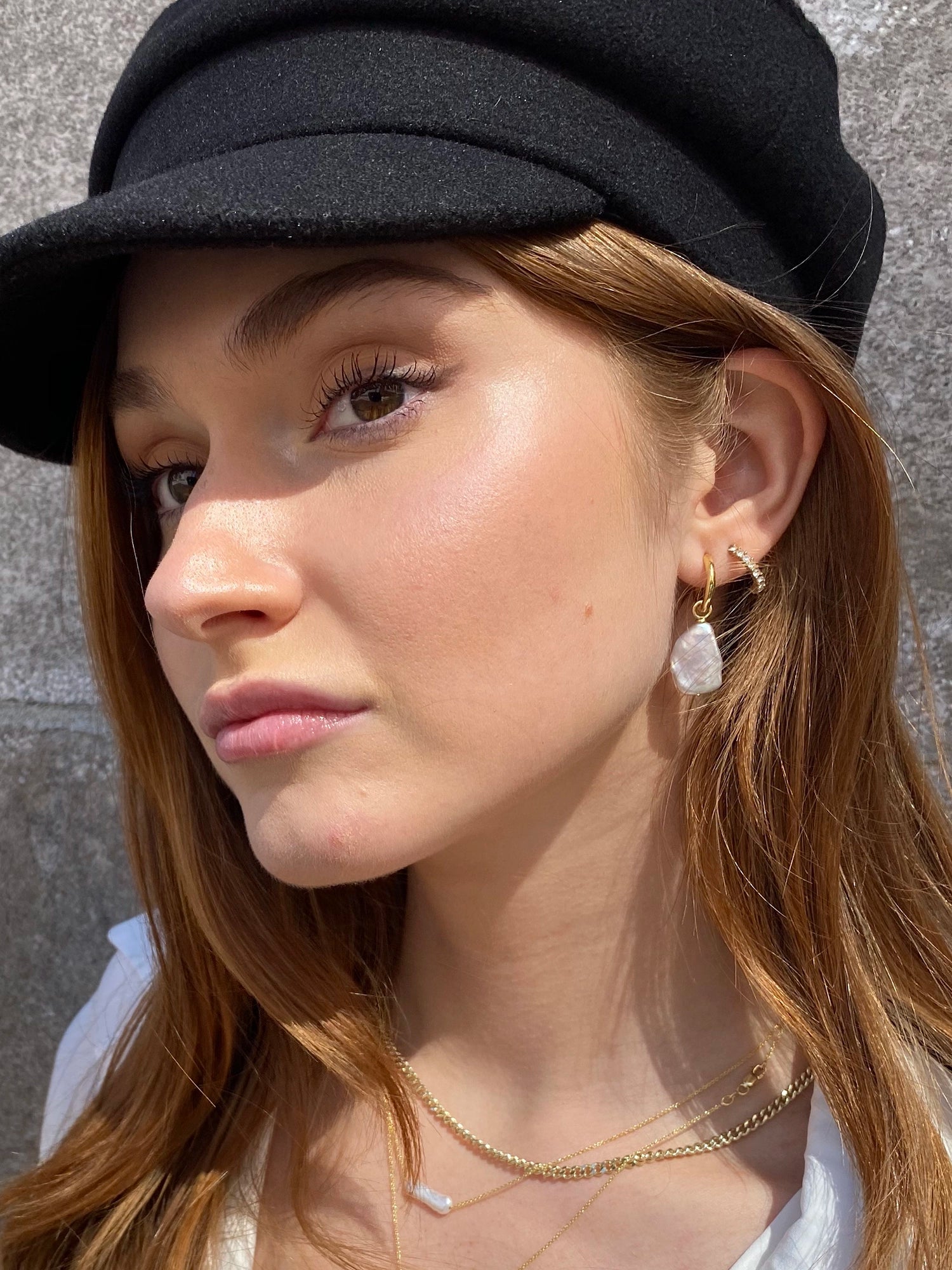 Azalea Hoops - mixed-size white baroque freshwater pearl earrings in yellow gold vermeil by Nishi Pearls, worn on a model
