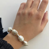 Baroque Bead Bracelet - mixed-size white baroque freshwater pearls in sterling silver, 7.5in by Nishi Pearls, worn on a model
