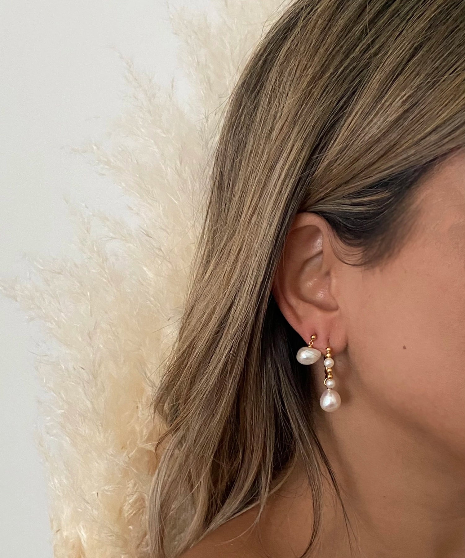 Beatrice Hoops - mixed-size white baroque freshwater pearl earrings in yellow gold vermeil by Nishi Pearls, worn on a model