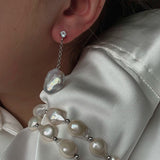 Bliss Earring - mixed-size white baroque freshwater pearl earrings in sterling silver by Nishi Pearls, worn on a model