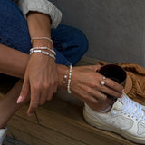 Cliquette Bracelet - 2-3mm white freshwater pearl magnetic bracelet in 14kt yellow gold by Nishi Pearls, styled on a model