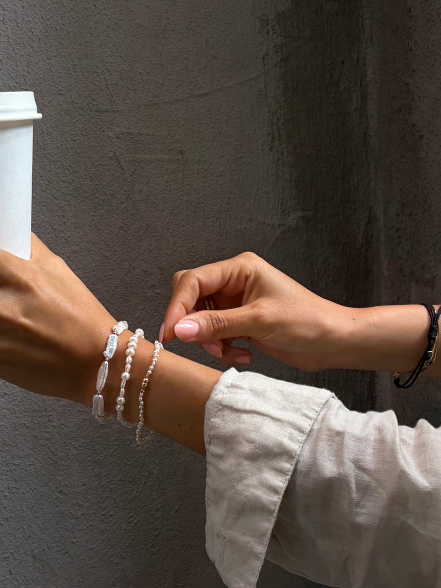 Cliquette Bracelet - 2-3mm white freshwater pearl magnetic bracelet in 14kt yellow gold by Nishi Pearls, worn on a model