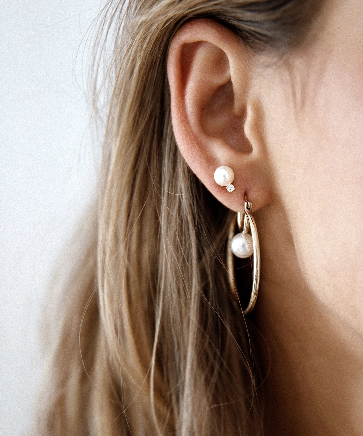 Cosmos Earring - 7-8mm white round freshwater pearl earrings in yellow gold vermeil by Nishi Pearls, worn on a model