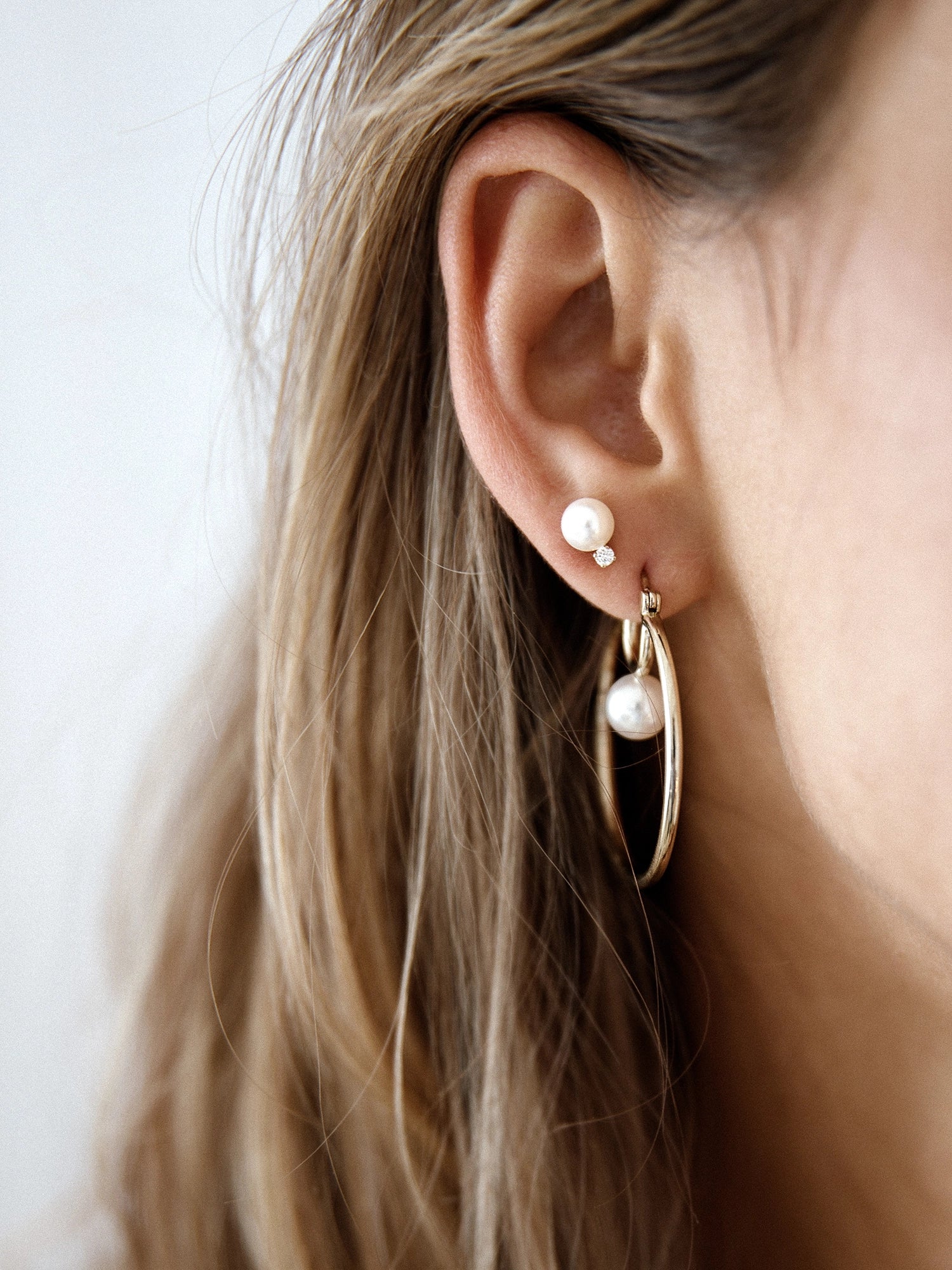 Cosmos Earring - 7-8mm white round freshwater pearl earrings in yellow gold vermeil by Nishi Pearls, worn on a model