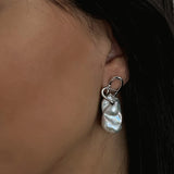 Curvella Earring - mixed-size white baroque freshwater pearl earrings in sterling silver by Nishi Pearls, worn on a model