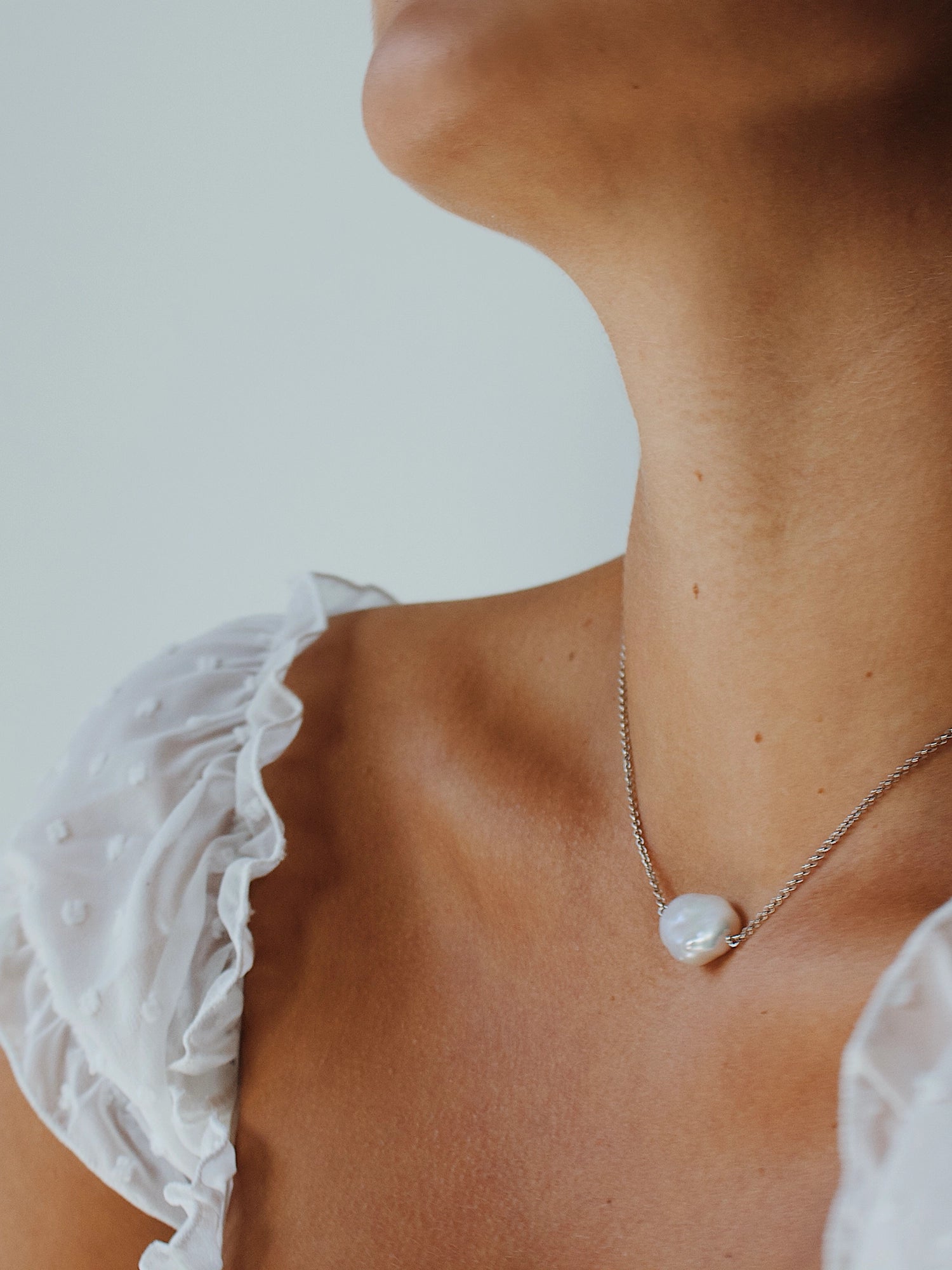 Daisy Necklace - 14-15mm white baroque freshwater pearls in sterling silver, 15-17in by Nishi Pearls, styled on a model