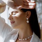 Daliah Earring - mixed-size white baroque freshwater pearl earrings in sterling silver by Nishi Pearls, worn on a model