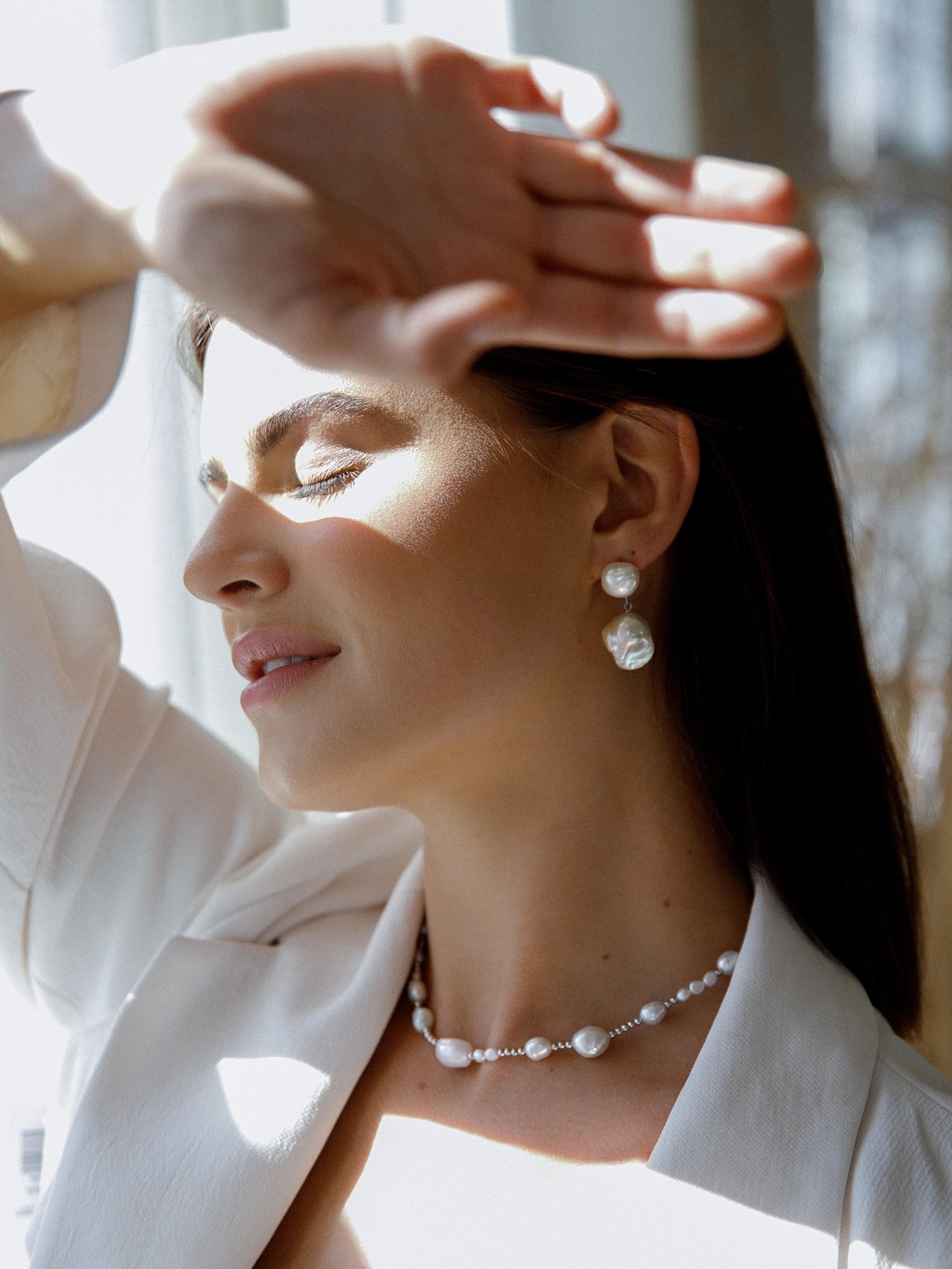 Daliah Earring - mixed-size white baroque freshwater pearl earrings in sterling silver by Nishi Pearls, worn on a model