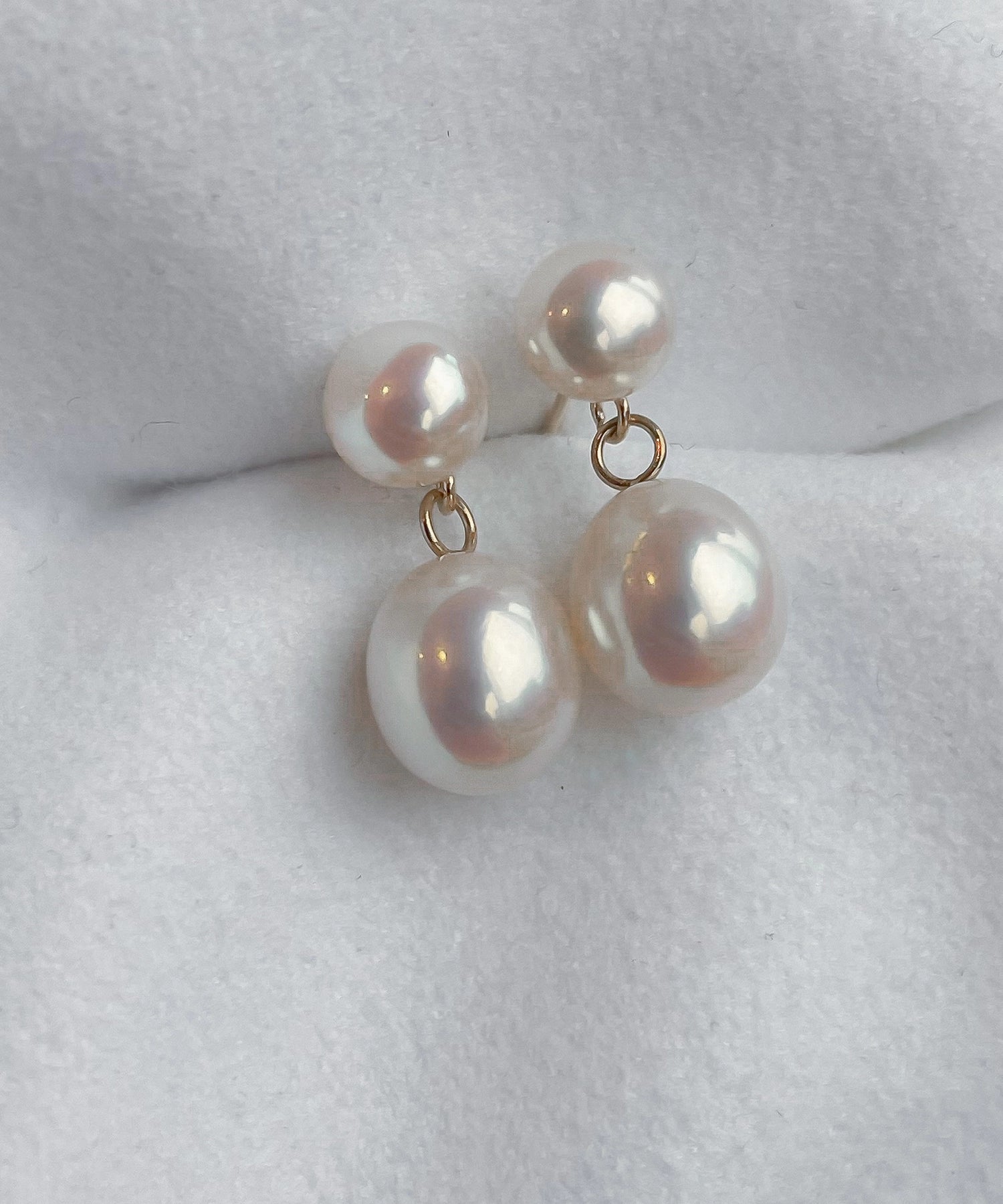 Drop Studs - mixed-size white freshwater pearl earrings in 14kt yellow gold by Nishi Pearls, styled lifestyle photo