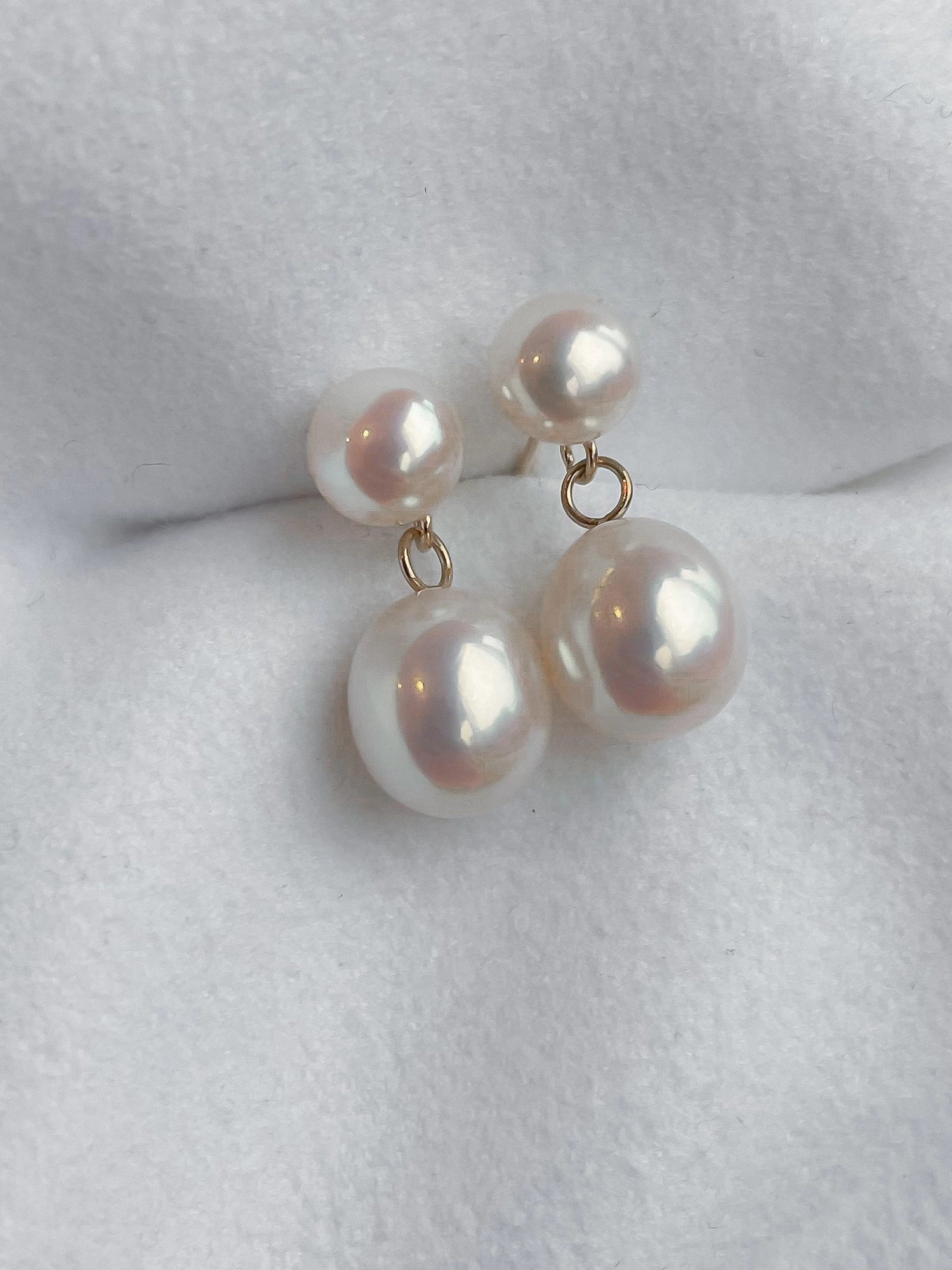 Drop Studs - mixed-size white freshwater pearl earrings in 14kt yellow gold by Nishi Pearls, styled lifestyle photo