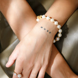 Gold Bead Bracelet - 9-10mm white freshwater pearl bracelet in yellow gold plated silver by Nishi Pearls, styled on a model