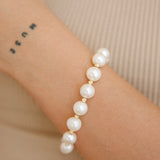Gold Bead Bracelet - 9-10mm white freshwater pearl bracelet in yellow gold plated silver by Nishi Pearls, worn on a model