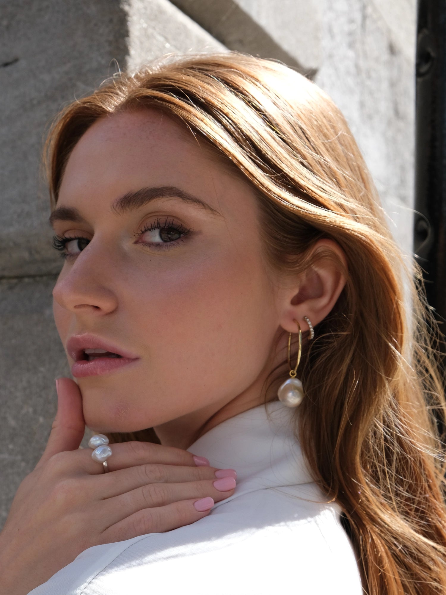 Holly Hoops - mixed-size white baroque freshwater pearl earrings in yellow gold vermeil, on a model by Nishi Pearls, angle