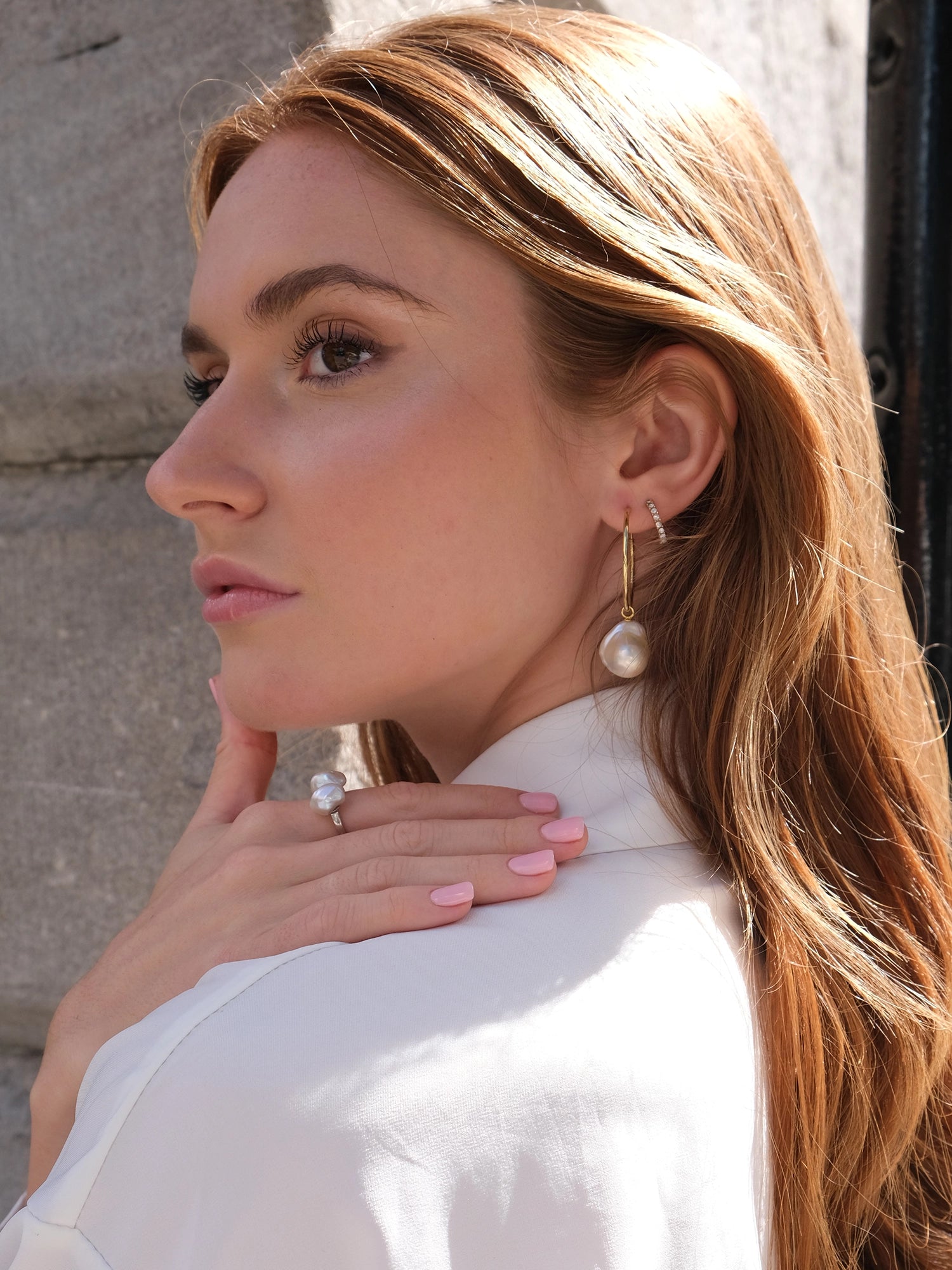 Holly Hoops - mixed-size white baroque freshwater pearl earrings in yellow gold vermeil by Nishi Pearls, worn on a model